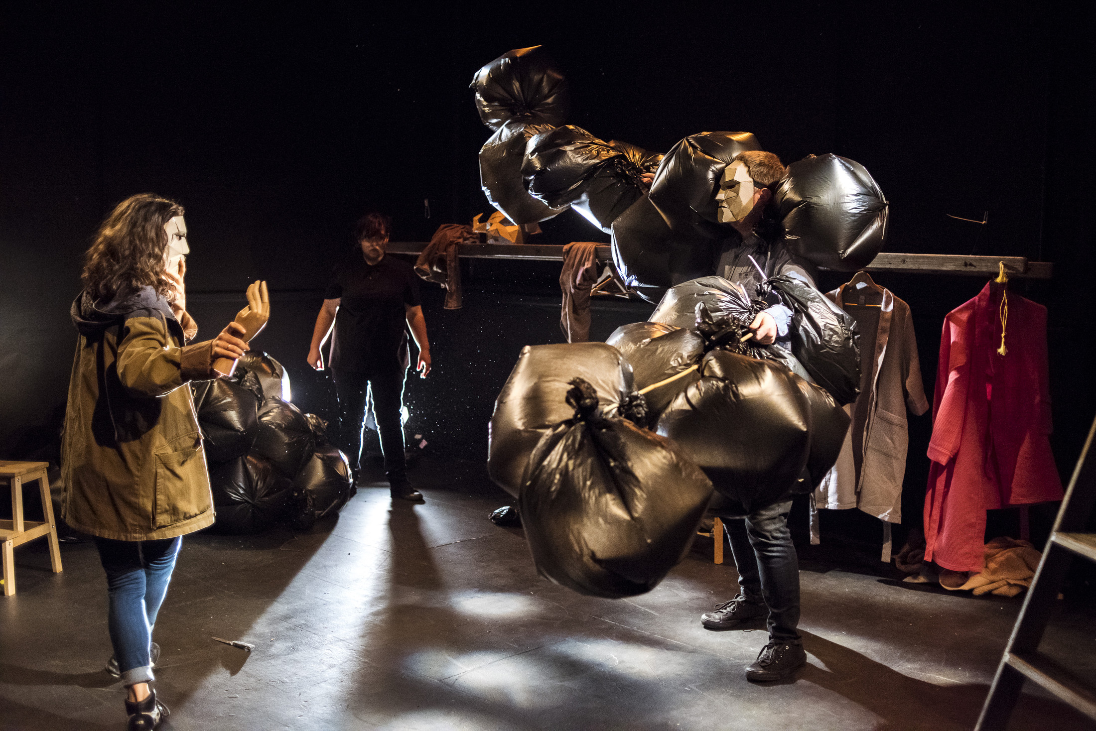 A masked figure confronts a creature made of black plastic bags in Girl in the Wood